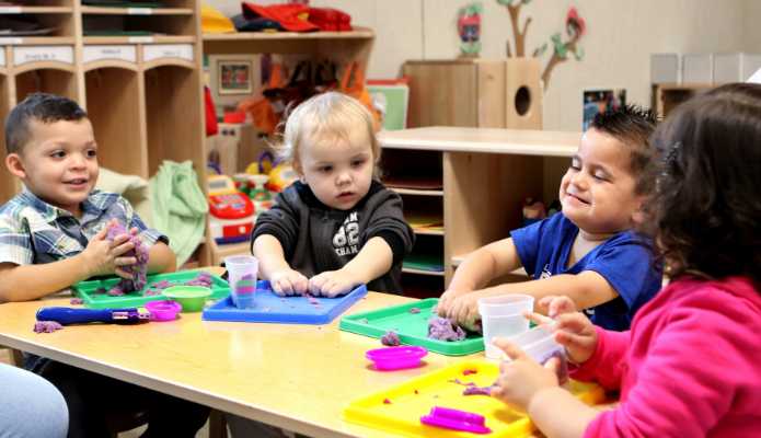 Head Start children playing with playdoh on the table